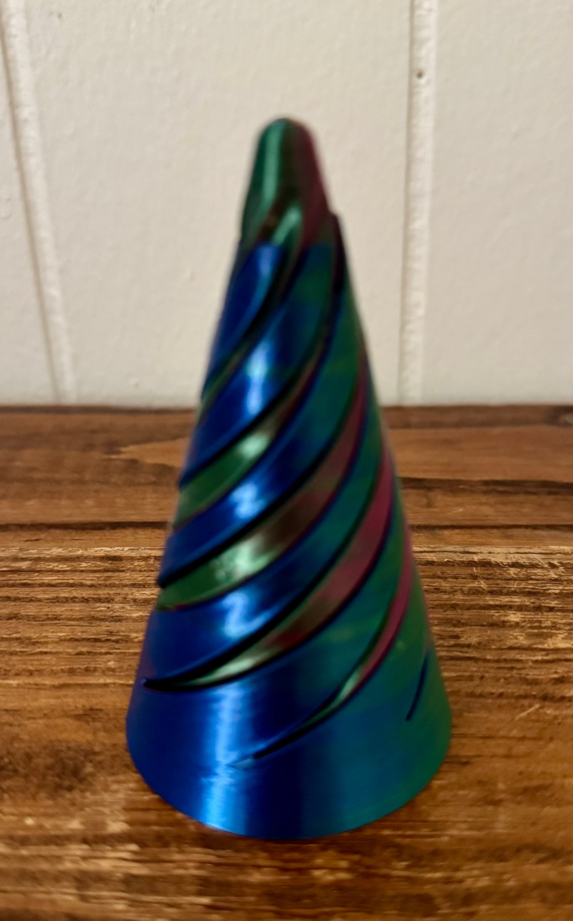 Colorful striped cone-shaped object on a wooden surface