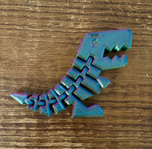 Iridescent metallic letter 'S' on a wooden surface