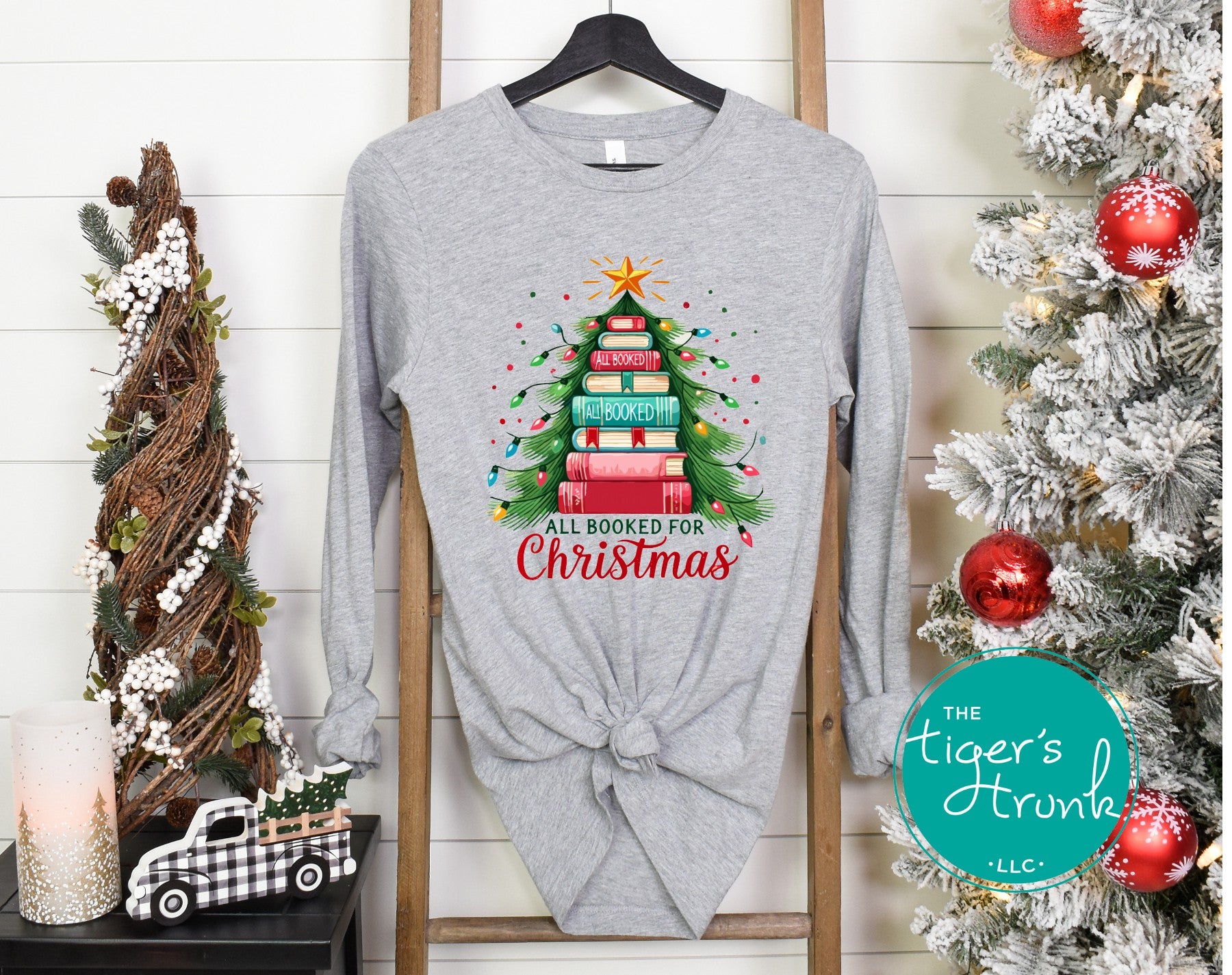 Adult long sleeve Christmas shirt with the phrase All Booked for Christmas and an image of a Christmas tree made of books