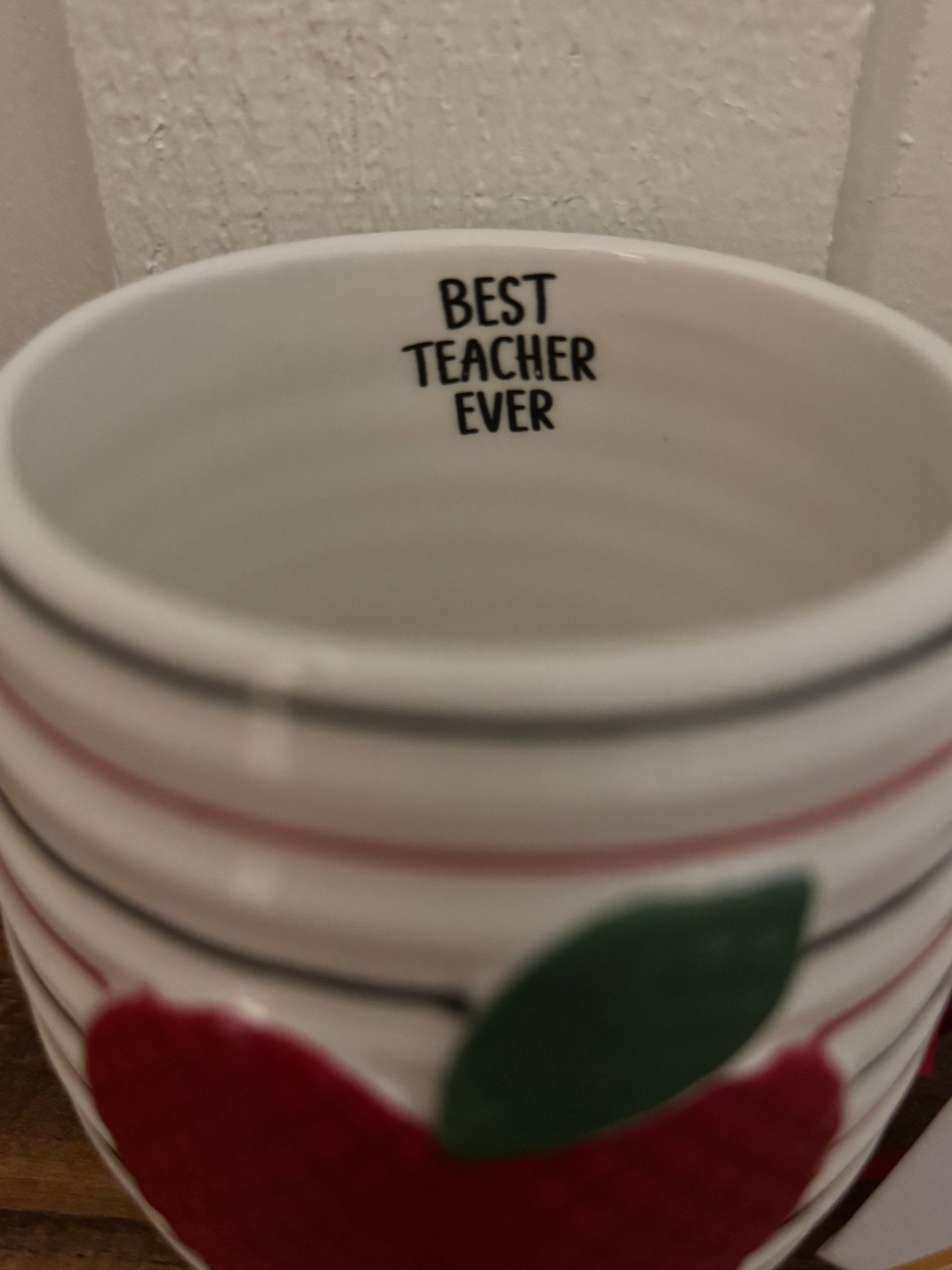 Ceramic mug with 'Best Teacher Ever' text and apple design on a white background