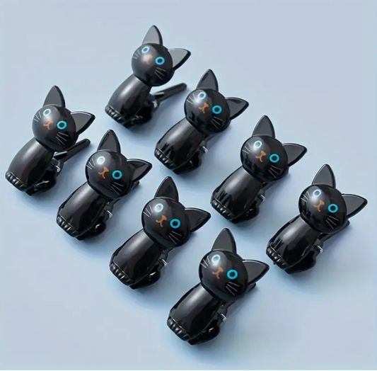 Black cat-shaped phone clips on a light blue background