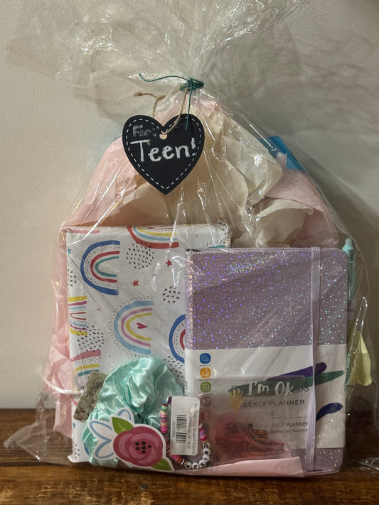 This Teen Gift Basket includes a blind date with a book, undated weekly planner, and cozy extras like a scrunchie, bracelet, stickers, pen, bookmark, and eye mask—perfect for readers and planners alike.