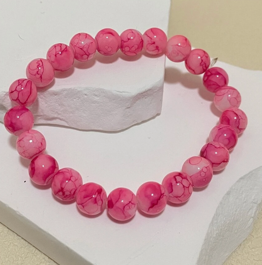 Pink beaded bracelet on a white surface