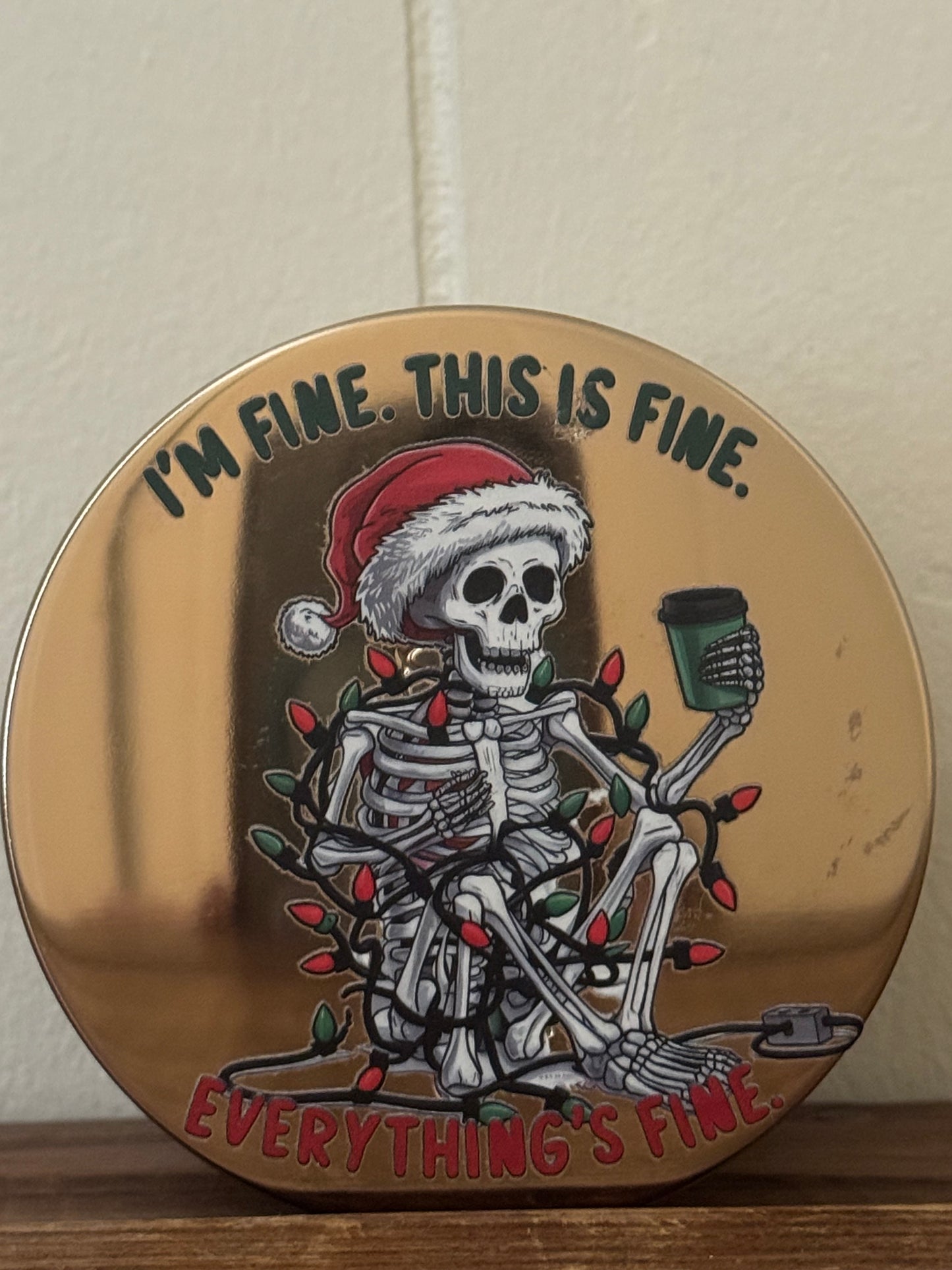 14.5 oz Christmas candle featuring a skeleton wearing a Santa hat, drinking coffee, and wrapped in Christmas lights