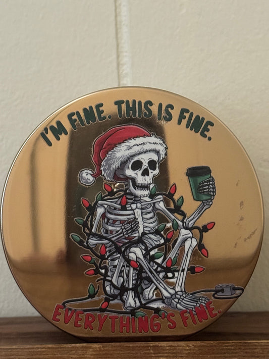 14.5 oz Christmas candle featuring a skeleton wearing a Santa hat, drinking coffee, and wrapped in Christmas lights