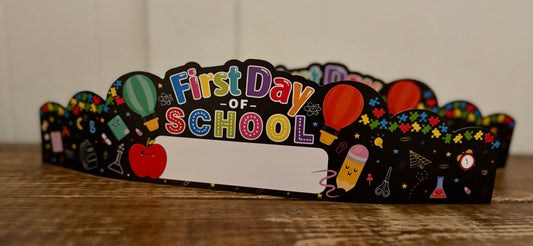 Decorative crown with 'First Day of School' text on a wooden surface
