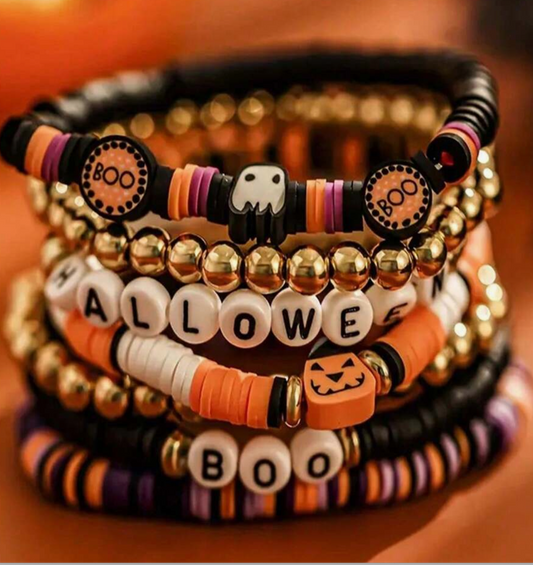 Stack of Halloween-themed beaded bracelets on a wooden surface