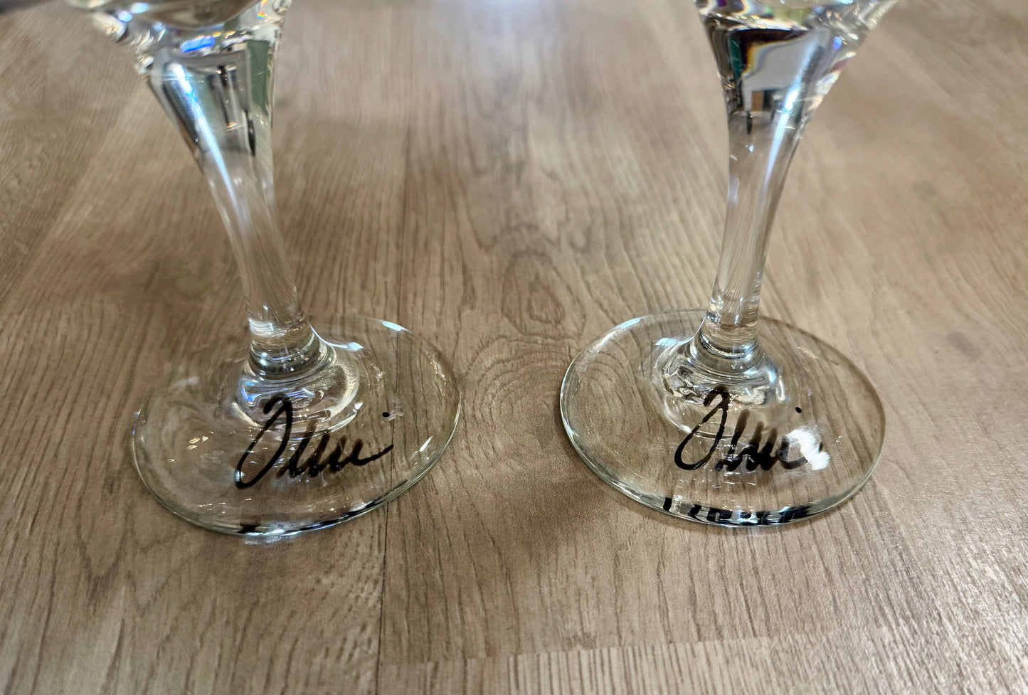 Pair of hand-painted wine glasses featuring colorful swirl square designs and signed glass bases