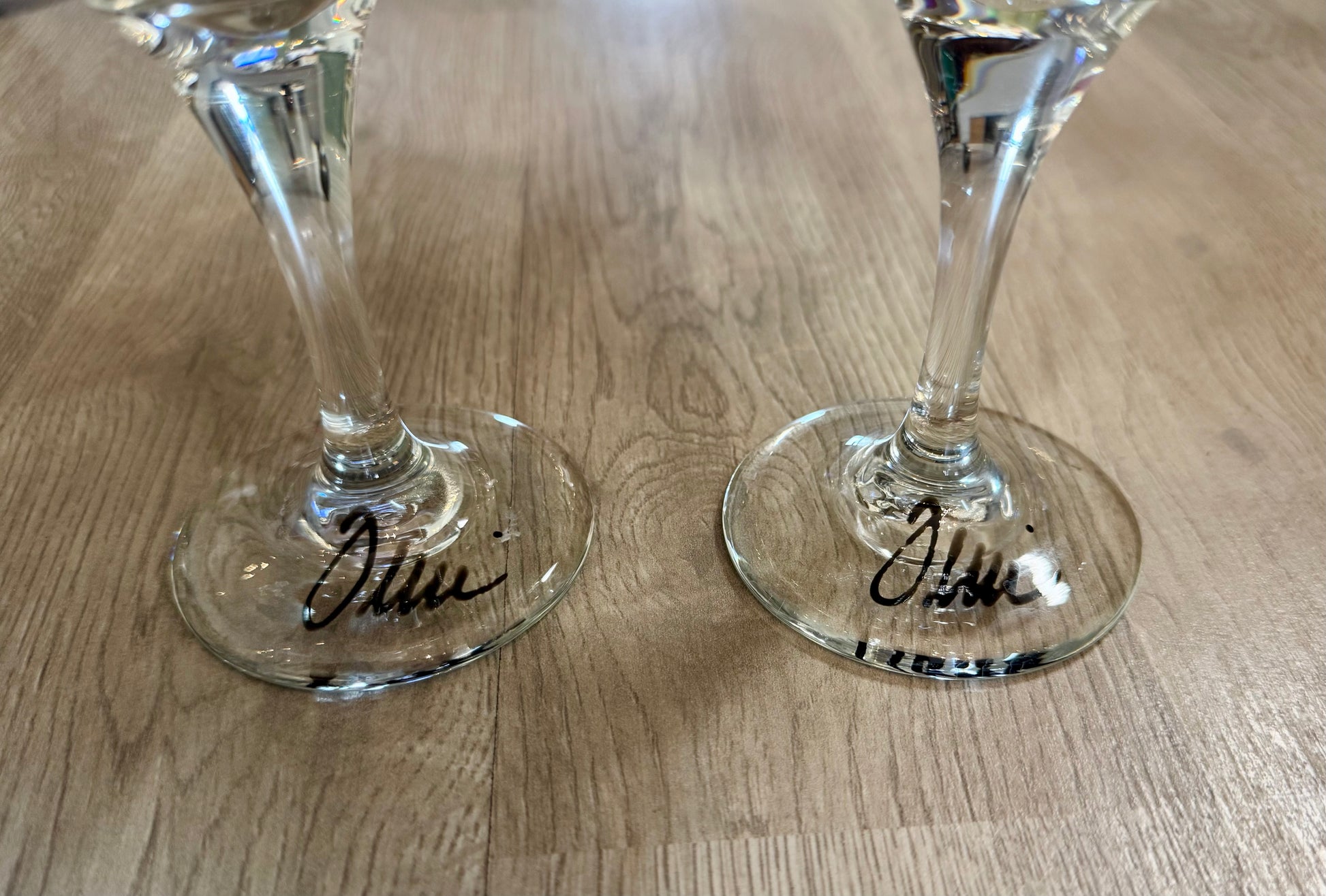 Pair of hand-painted wine glasses featuring colorful swirl square designs and signed glass bases