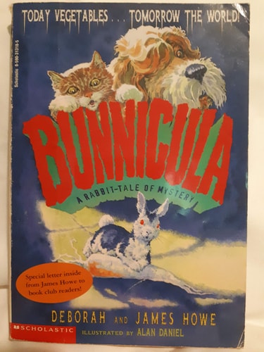 Cover of Bunnicula by Deborah and James Howe — a rabbit with fangs in a pet carrier, dog and cat watching suspiciously