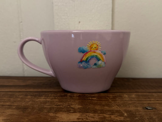 Lavender ceramic mug with rainbow design on the outside and a purple heart at the bottom inside