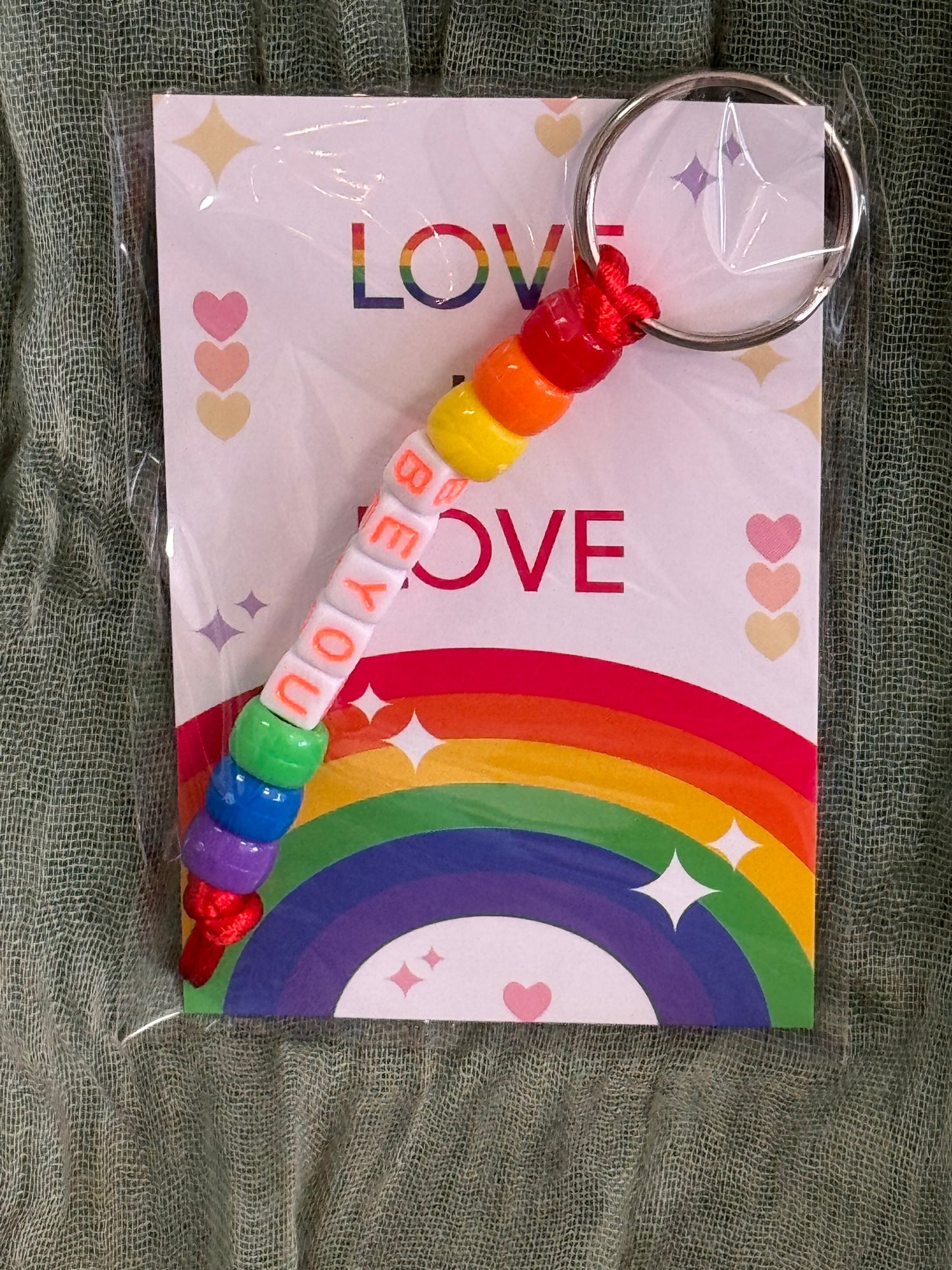 Beaded rainbow Pride keychain with word bead charms like Pride and Love on a Love is Love card