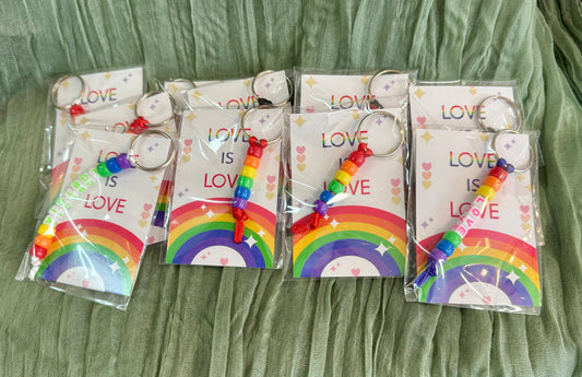 Beaded rainbow Pride keychain with word bead charms like Pride and Love on a Love is Love card