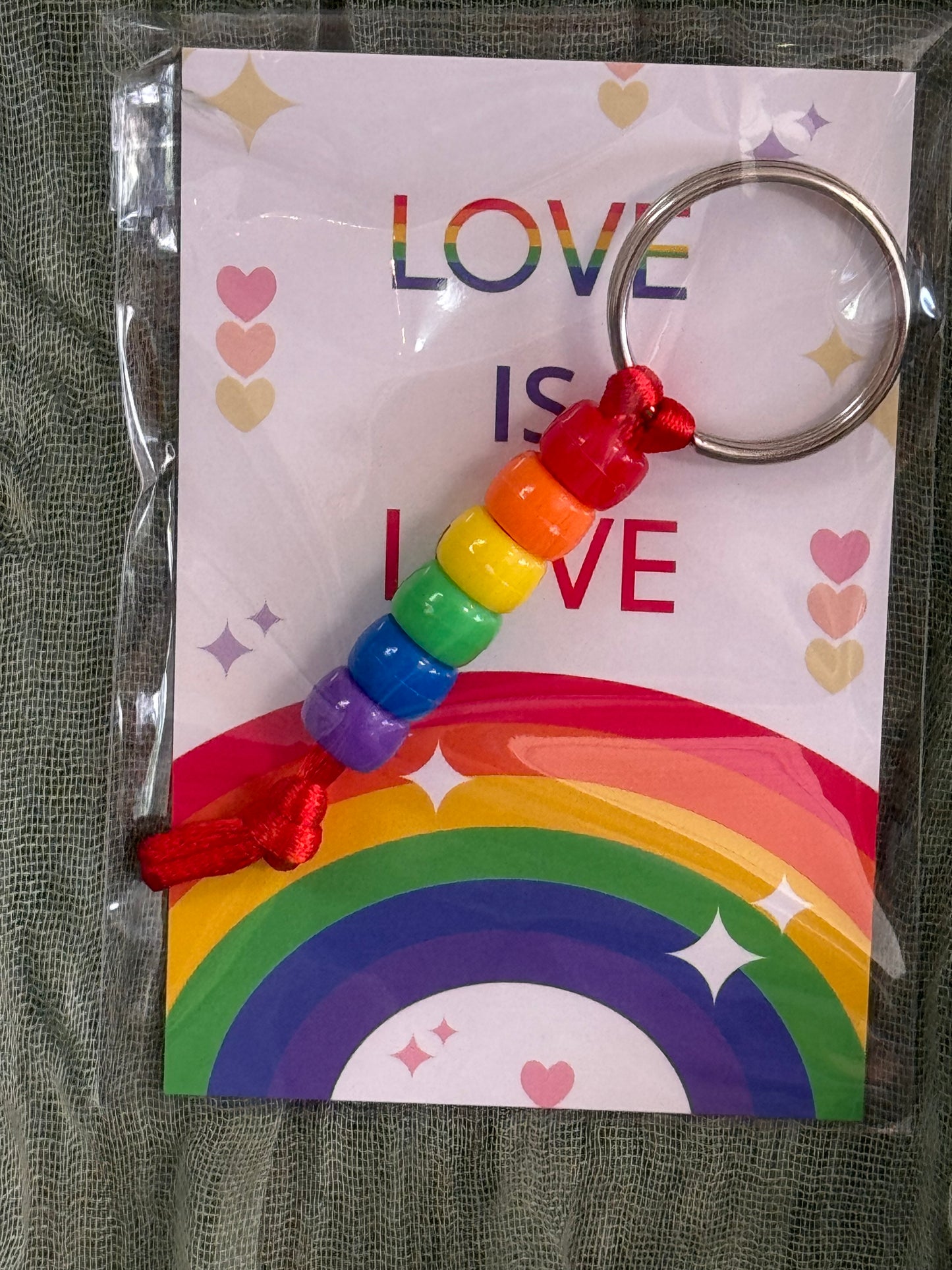 Beaded rainbow Pride keychain with word bead charms like Pride and Love on a Love is Love card