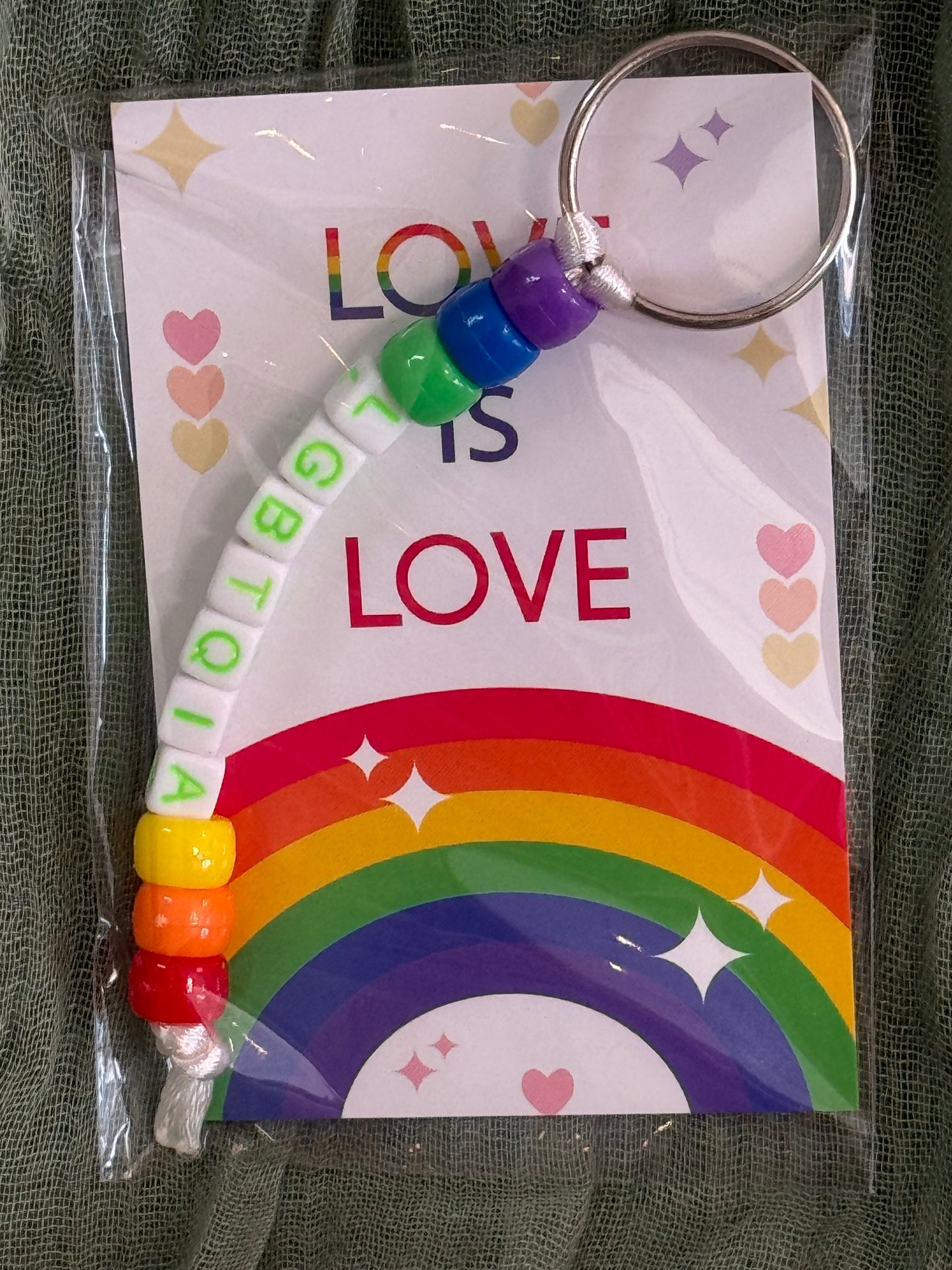 Beaded rainbow Pride keychain with word bead charms like Pride and Love on a Love is Love card