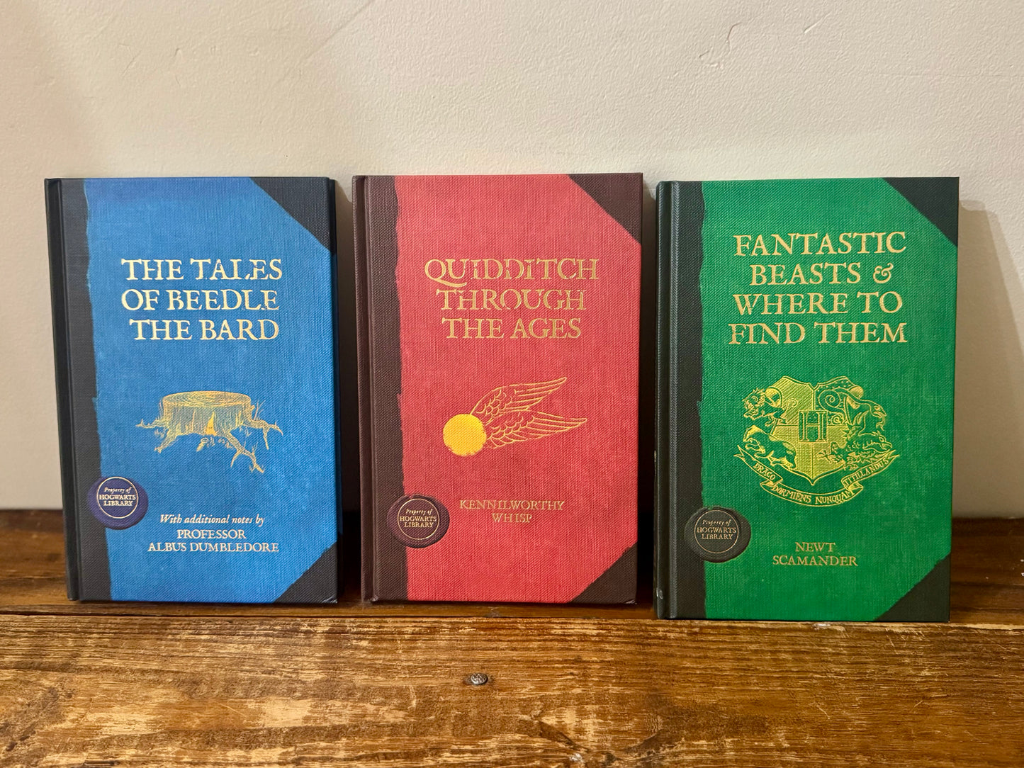 Cover of Hogwarts Library 3-book collection by J.K. Rowling, featuring Fantastic Beasts and Where to Find Them, Quidditch Through the Ages, and The Tales of Beedle the Bard in a themed slipcase.