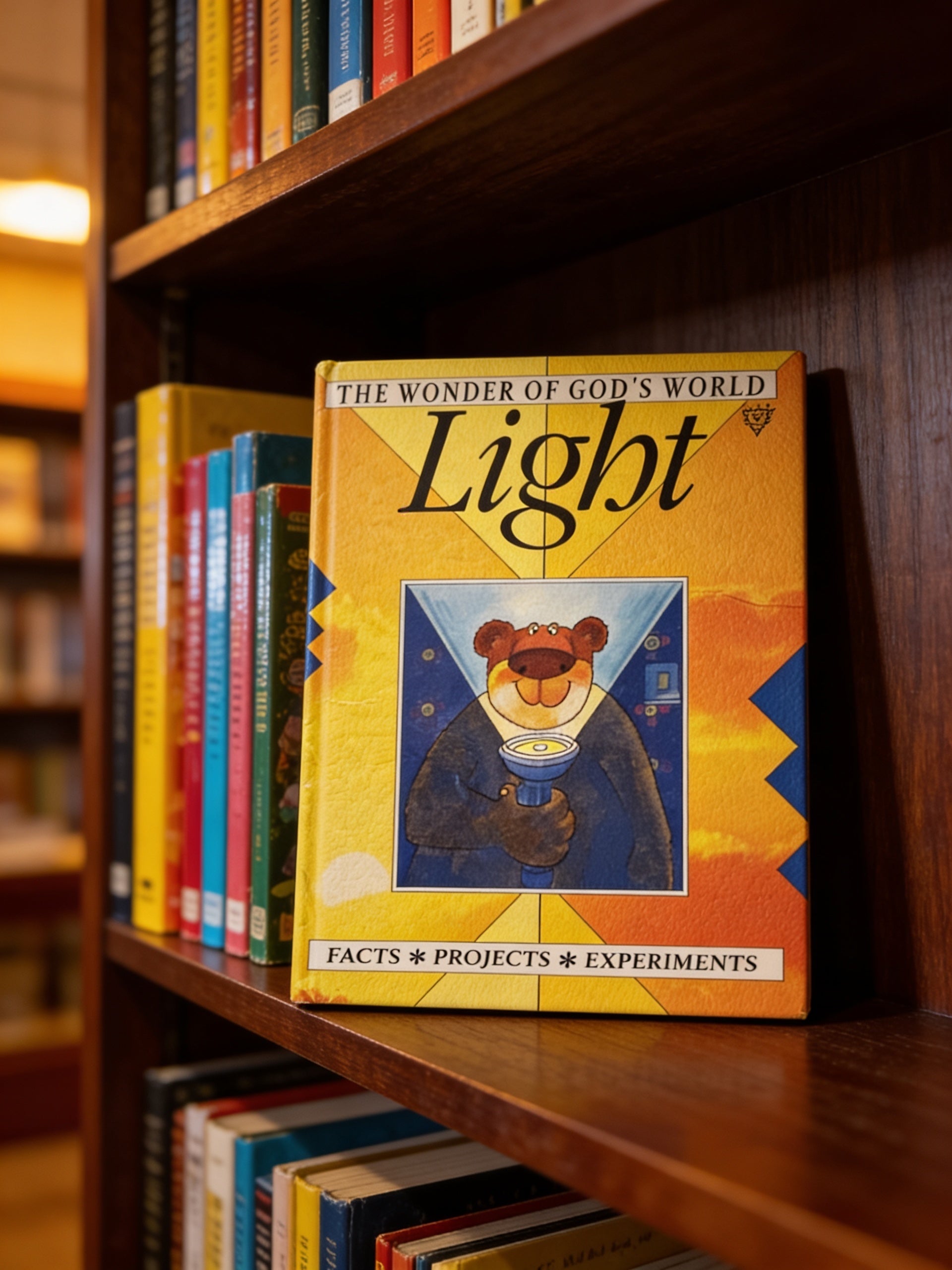 Book titled 'The Wonder of God's World Light' on a bookshelf with other books.
