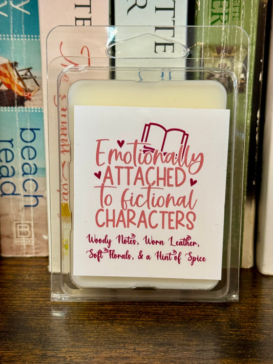 Soy wax melts labeled "Emotionally Attached to Fictional Characters," scented with woody notes, worn leather, soft florals, and a hint of spice.