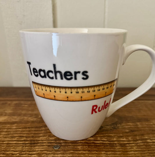 White ceramic mug with the phrase Teachers Rule and a printed ruler graphic