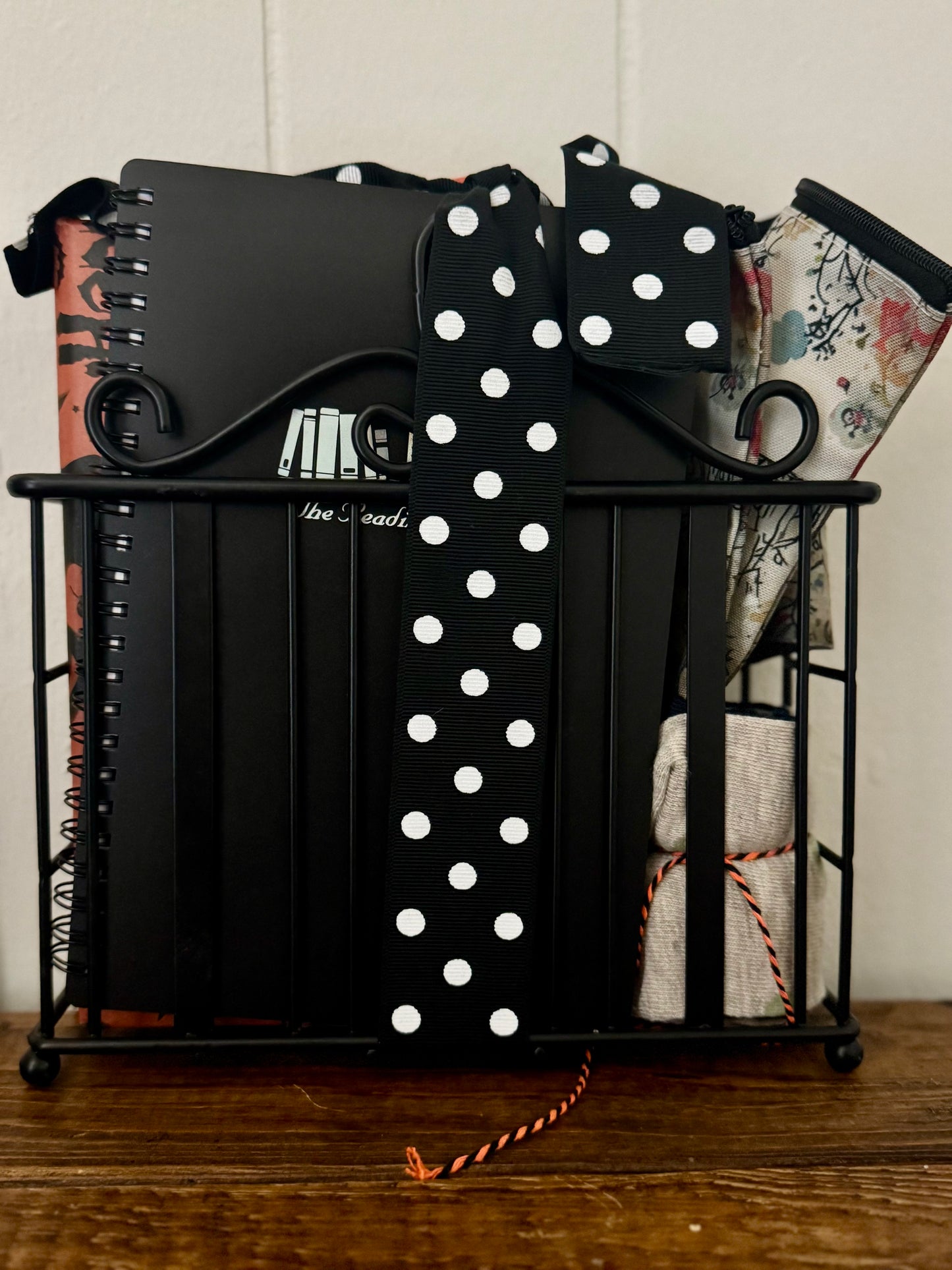 Black decorative item with a polka dot bow on a wooden surface