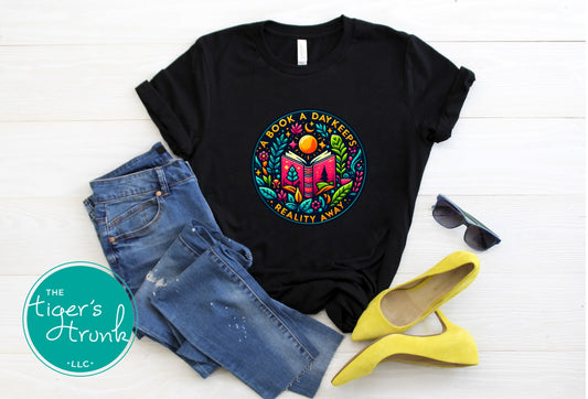Black t-shirt with colorful graphic design, blue jeans, yellow shoes, and sunglasses on a white background.