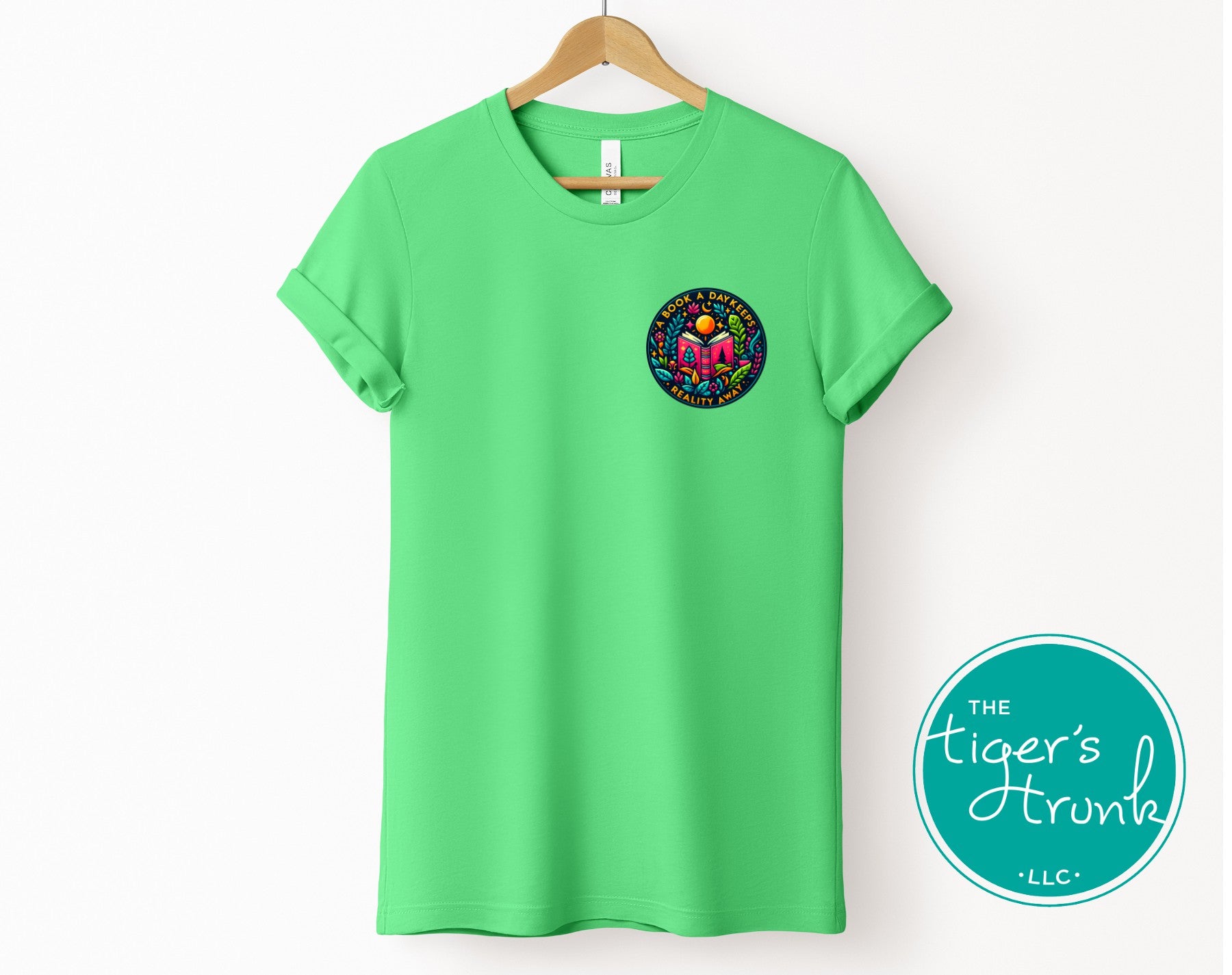 Green t-shirt with a logo on a hanger, featuring 'The Tiger's Trunk LLC' brand.