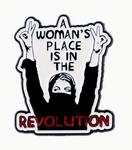 A Woman’s Place Is in the Revolution enamel pin with bold lettering, feminist empowerment accessory for jackets and bags