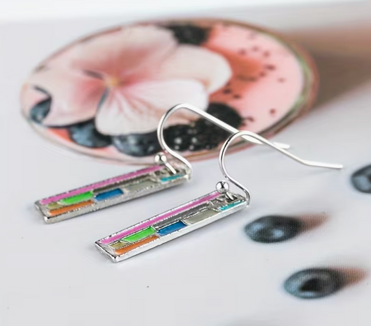 colorful abstract bookshelf earrings displayed on a flatlay with soft floral decor