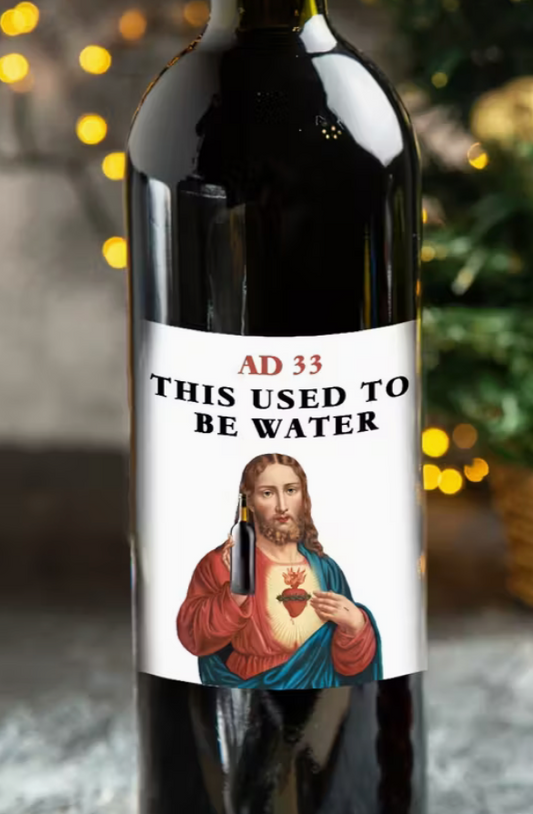 Wine bottle with humorous label reading “AD 33 This Used to Be Water” featuring Jesus illustration and holiday lights