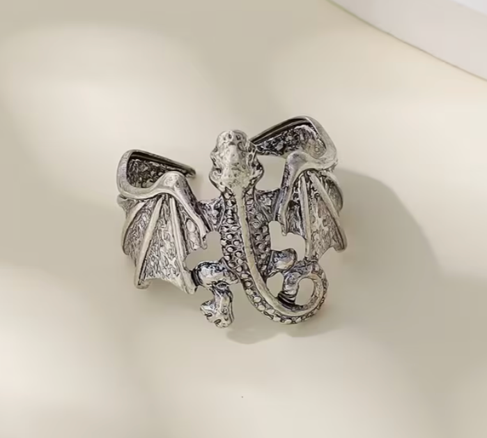 Front view of adjustable silver-toned dragon ring with detailed wings, curled tail, and textured dragon body