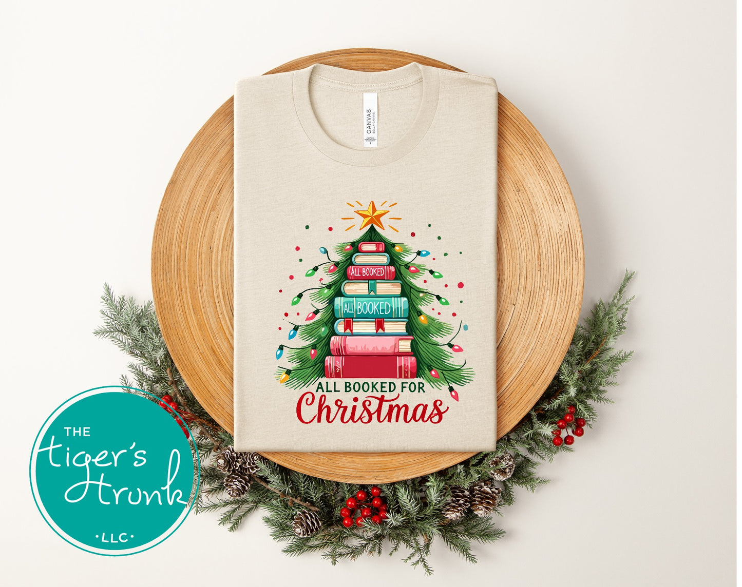 Natural heather short-sleeve shirt featuring a festive stacked book Christmas tree with colorful lights and the words "All Booked for Christmas."