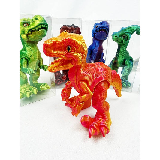 Large 3D printed articulated dinosaur figure standing approximately 7 inches tall with movable joints, displayed in a clear gift box with other colorful dinosaur figures in the background