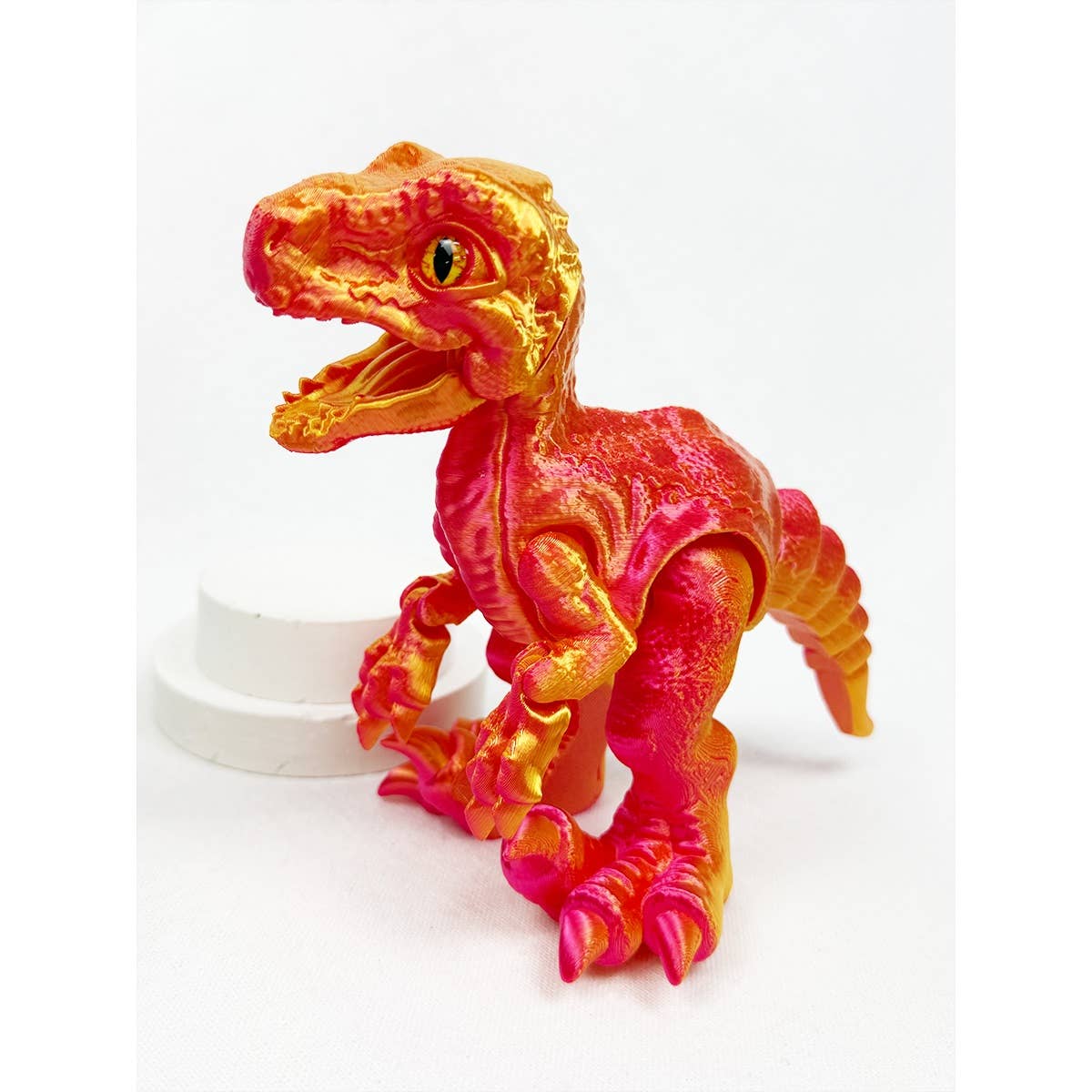 Red and orange 3D printed articulated dinosaur figure with movable joints, approximately 7 inches tall, posed on a white background