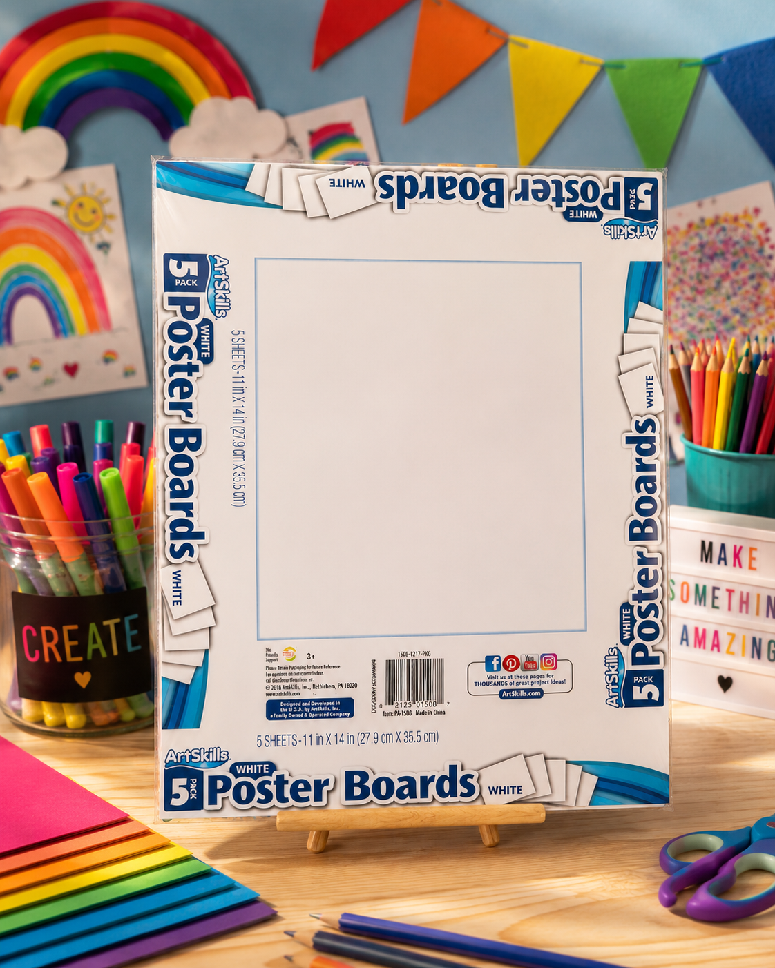 Pack of five ArtSkills white poster boards measuring 11 x 14 inches displayed on a tabletop surrounded by colorful craft supplies, markers, pencils, and classroom decorations.