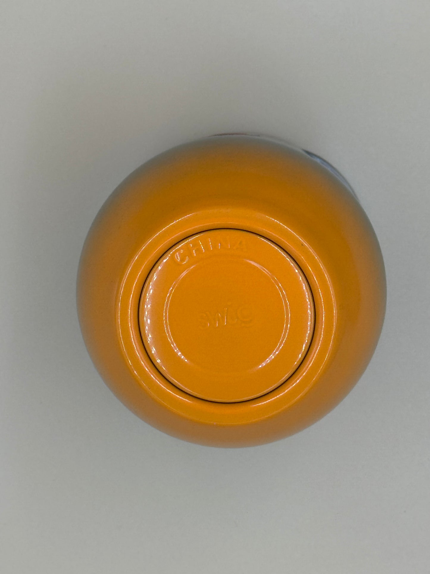 Yellow jar with a lid on a light gray background