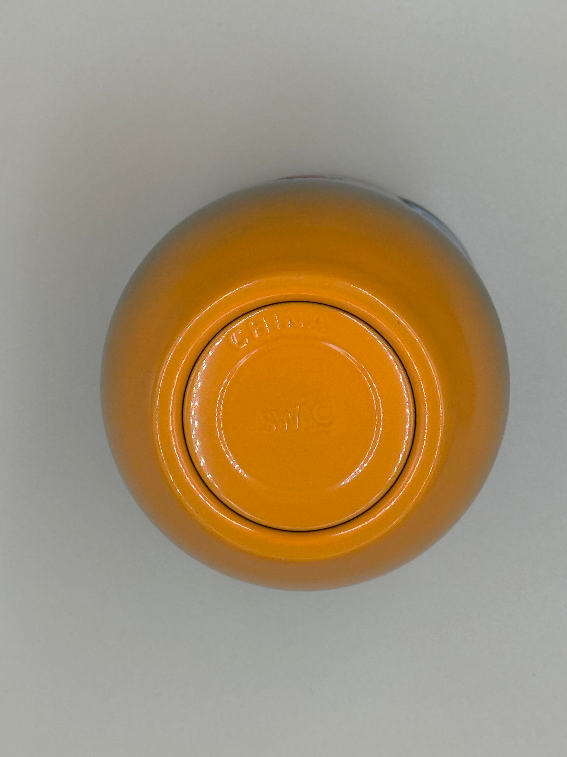 Yellow jar with a lid on a light gray background