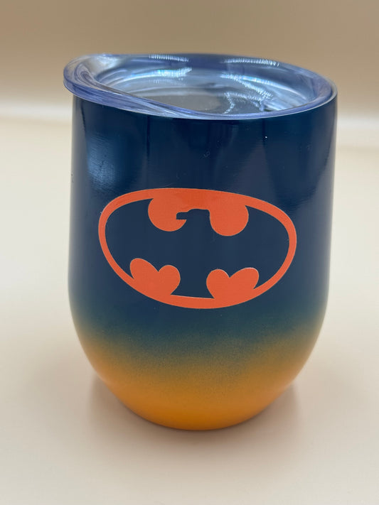 Blue and orange tumbler with orange bat symbol on a beige background