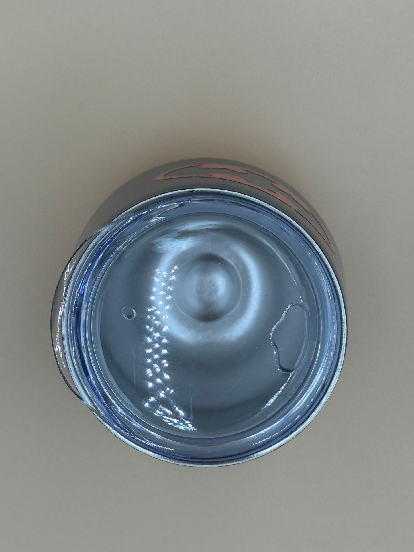 Top view of a metallic can on a beige background