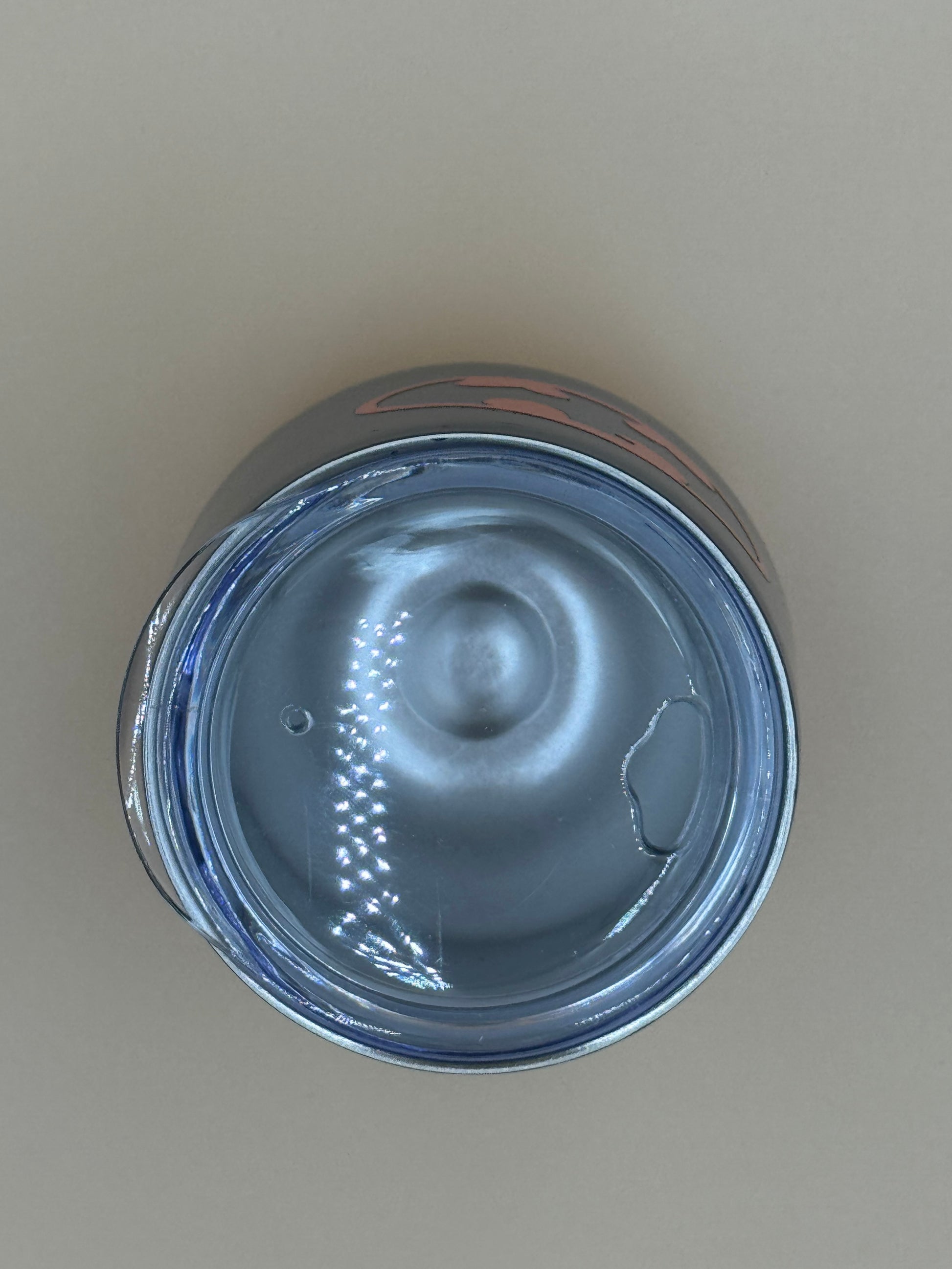 Top view of a metallic can on a beige background