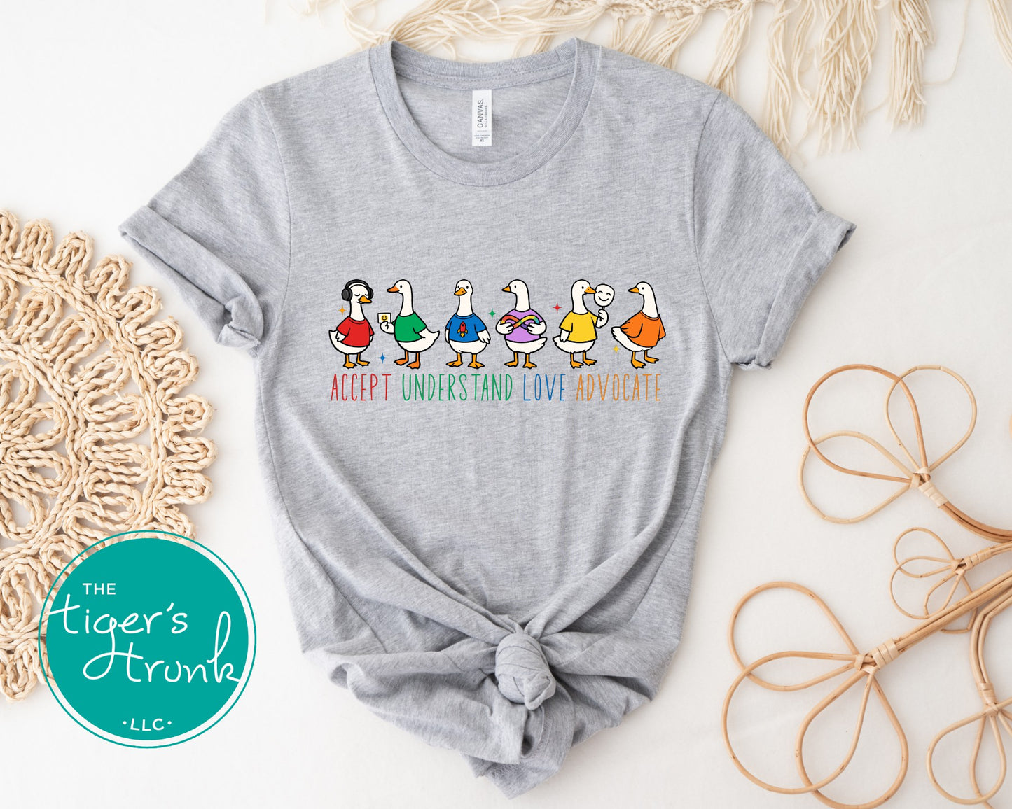 Gray t-shirt with colorful duck graphic and text on a light background, featuring 'The Tiger's Trunk' logo.