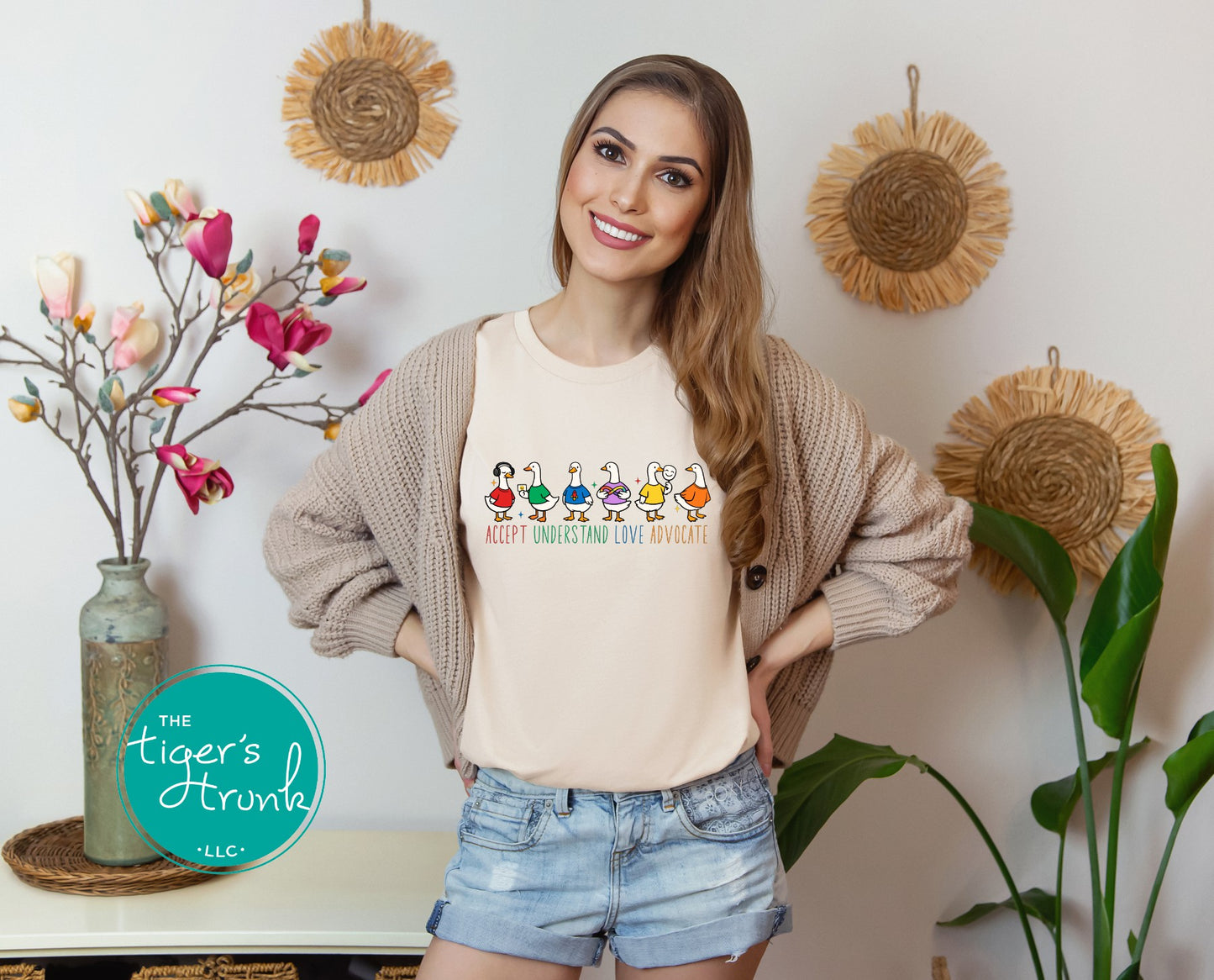 Woman wearing a t-shirt with colorful graphics and text, standing in a room with decorative elements.