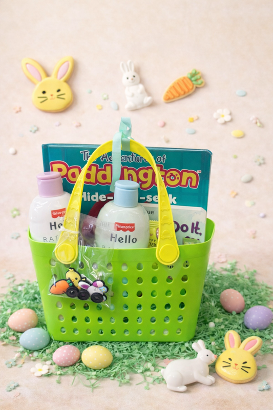 Green baby Easter basket filled with board books, baby wash, baby lotion, and spring treats styled with pastel eggs and bunny decorations.