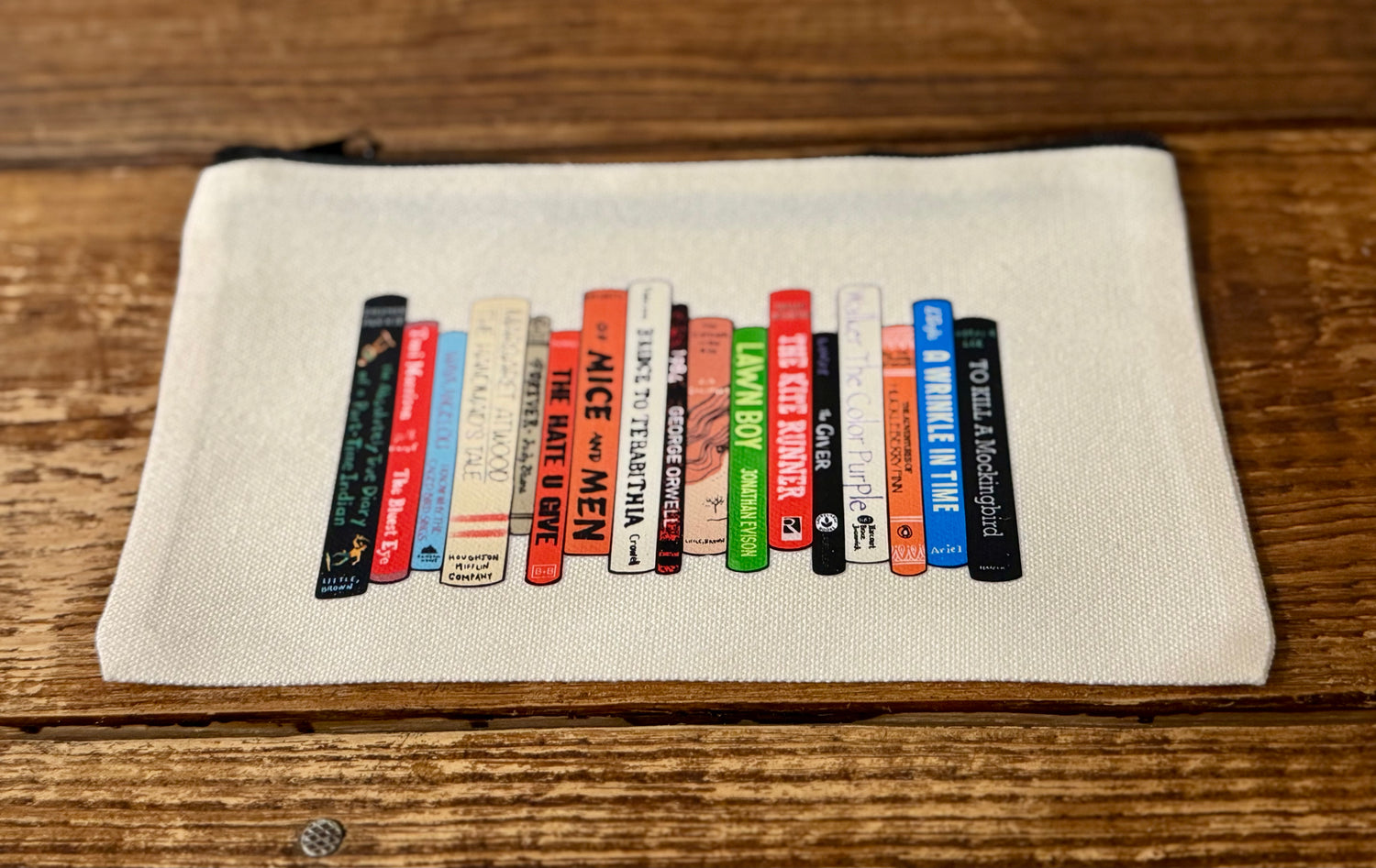  5"x8" zippered carry-all bag featuring an illustration of a stack of frequently banned books, celebrating the fight against censorship and the power of literature.