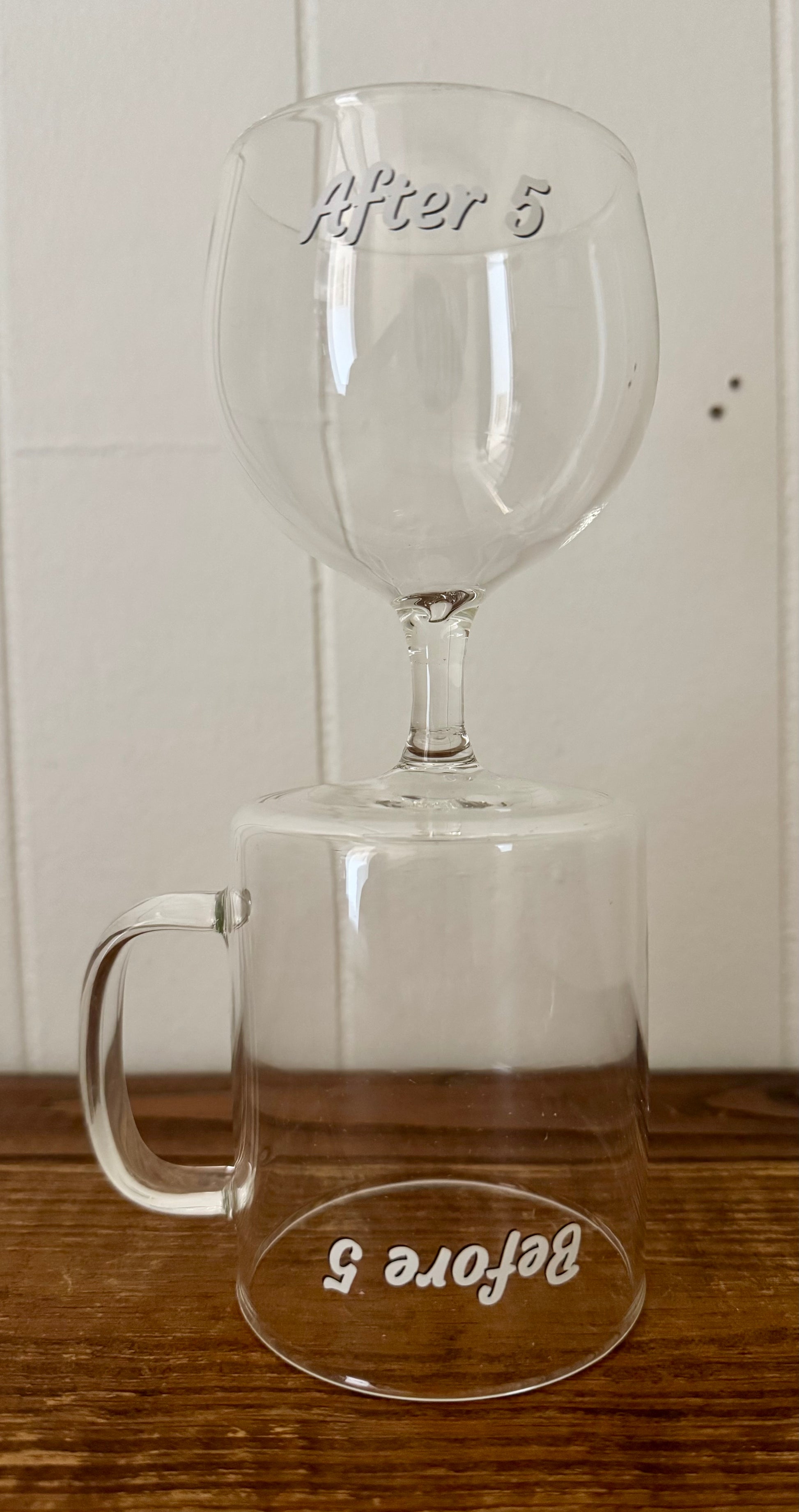 Clear glass mug with 'Before 5' and 'After 5' text on a wooden surface.