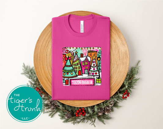 Berry pink Christmas shirt with a whimsical Christmas village and 35094 Leeds AL printed on the artwork.