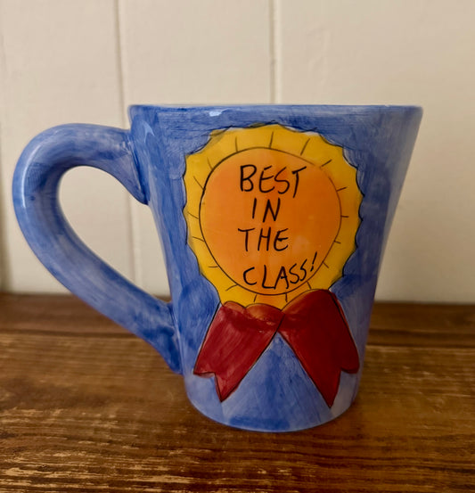 Blue mug with 'Best in the Class' design on a wooden surface