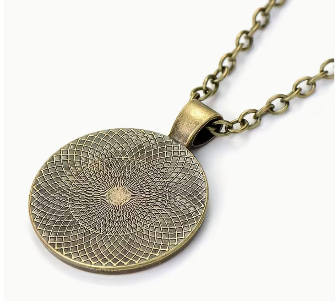 An antique bronze oval pendant necklace with a detailed sunburst geometric pattern, shown on a clean white background.