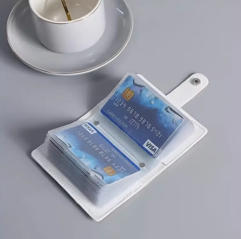 Card holder with multiple cards on a gray surface next to a white cup and saucer.