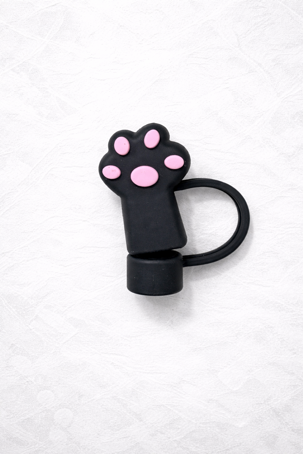 Black cat paw–shaped silicone straw topper with pink paw pad details and attached flexible loop for reusable tumbler straw.
