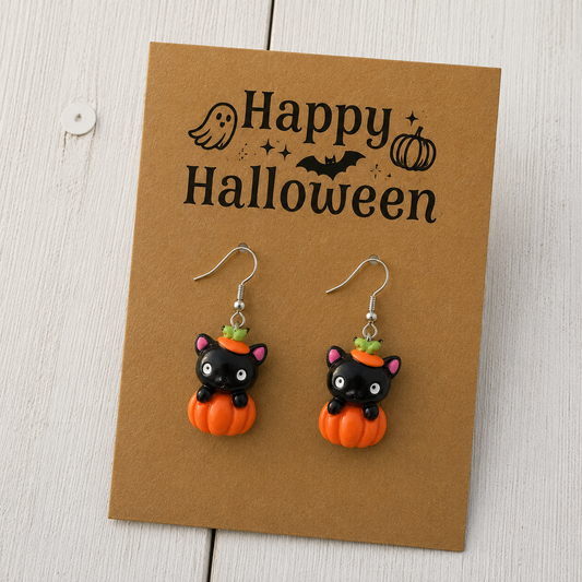 Black cat and orange pumpkin resin dangle earrings with silver-tone hooks for Halloween.